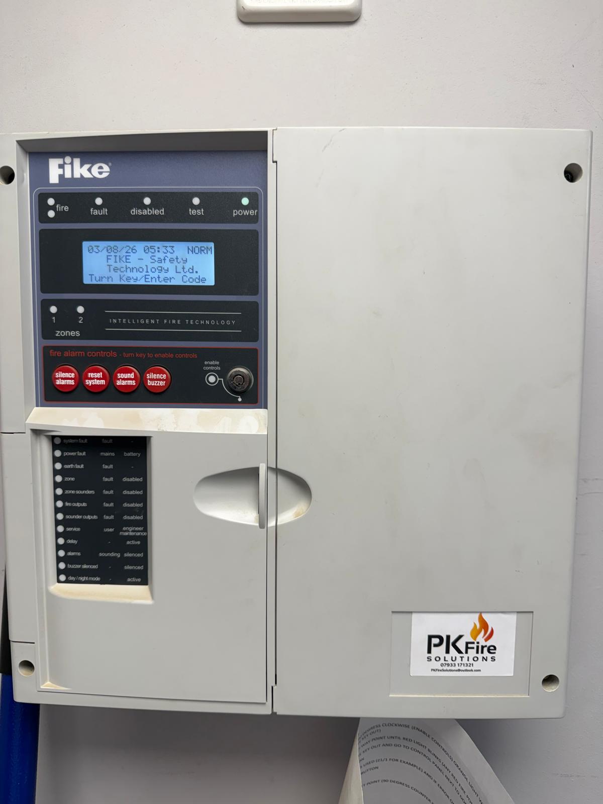 Fire alarm control panel with PK Fire Solutions branding